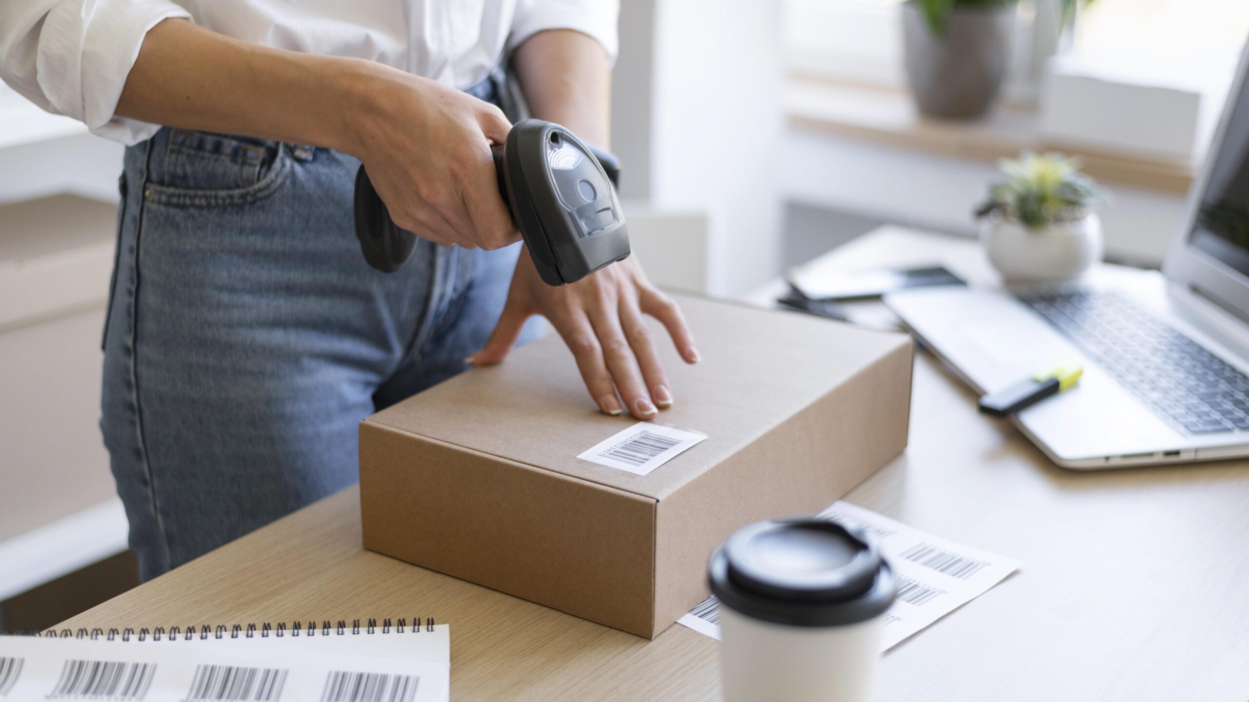 Woman scanning label on package with a barcode scanner.